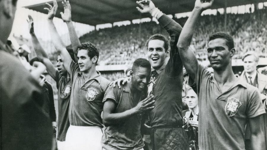29.jun.1958 - Pelé, então com dezessete anos, chora no ombro do goleiro Gilmar dos Santos Neves, ao lado do companheiro da seleção brasileira Didi, após a vitória por 5 a 2 do Brasil sobre a Suécia na final da Copa do Mundo de futebol de 58, em Estocolmo.