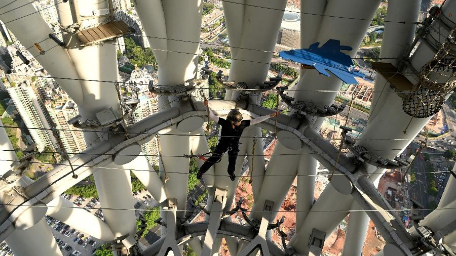 Guia atravessa a Canton Tower - NOEL CELIS/AFP