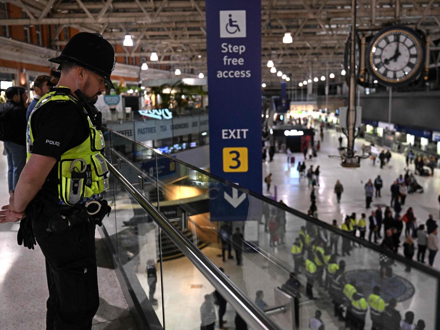 Policial observa um minuto de silêncio em homenagem a rainha Elizabeth 2ª, na estação de trem Waterloo, em Londres - Carl de Souza/AFP