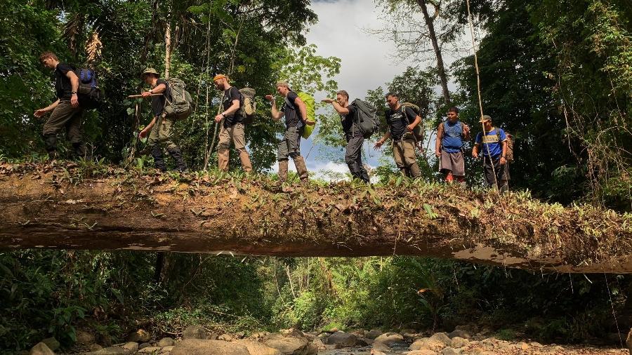 Turistas passam por tronco de árvore sobre rio no Tapón del Darién - Rick Morales/Jungle Treks