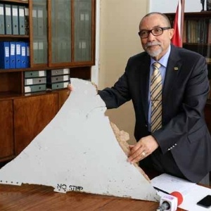 João de Abreu, presidente do Instituto de Aviação Civil de Moçambique, mostra possível destroço do voo MH370 encontrado no país - Adrien Barbier/AFP