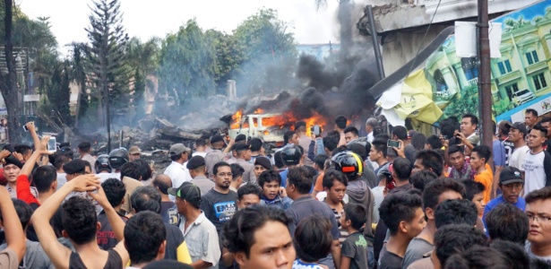 O avião caiu sobre uma casa e um hotel, incendiando os edifícios e veículos próximos - Muhammad Zulfan Dalimunthe/AFP