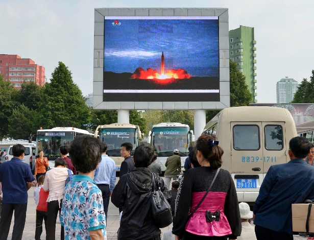 Norte-coreanos observam telão com imagem de lançamento de míssil balístico, em Pyongyang - Kyodo via Reuters