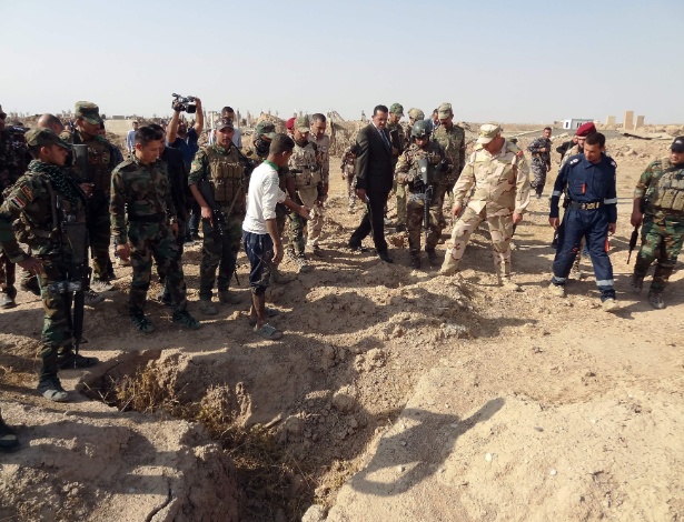 Forças iraquianas verificam uma cova suspeita de conter os restos das vítimas do grupo do Estado islâmico, perto da antiga base militar de al bakara - MARWAN IBRAHIM/AFP
