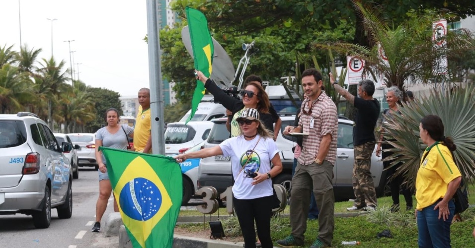 Confiantes, apoiadores de Jair Bolsonaro agitam bandeira do Brasil na Barra da Tijuca, zona oeste do Rio de Janeiro