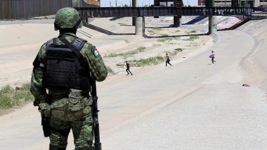 Soldado da Guarda Nacional Mexicana observa imigrantes tentato cruzar ilegalmente a fronteira com os EUA em Ciudad Juarez - Carlos Sanchez/Reuters