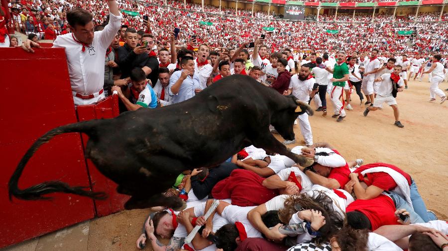 Uma touro pula sobre os foliões após a última corrida no festival de São Firmino, em Pamplona, Espanha - REUTERS / Susana Vera