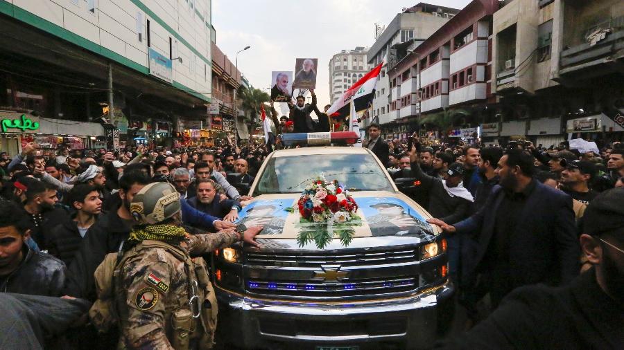 Iraquianos acompanham procissão com o caixão do comandante militar  iraquiano, Abu Mahdi al-Muhandis, em Bagdá. Ele foi morto em um ataque aéreo dos EUA na quinta-feira, na capital do Iraque - SABAH ARAR/AFP