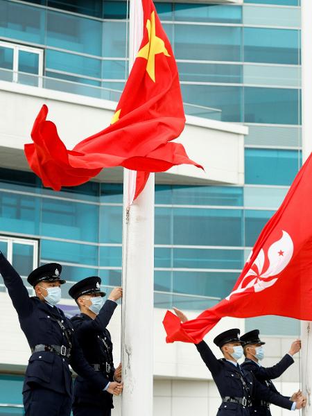 Policiais ao lado das bandeiras da China e de Hong Kong, em cerimônia oficial em Hong Kong - Tyrone Siu/Reuters