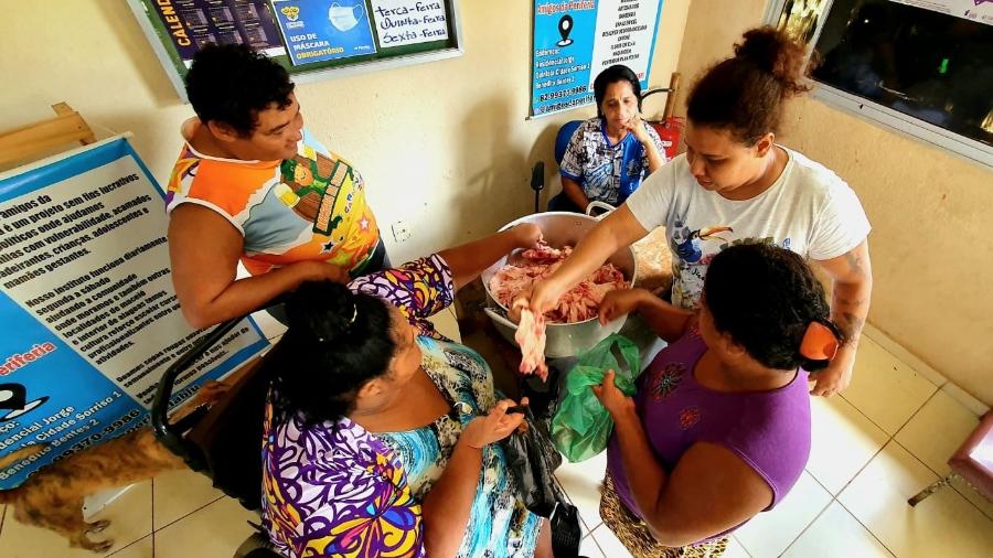 Mulheres disputam melhores pedaços de pele de frango doados por ONG de Maceió - Carlos Madeiro/UOL