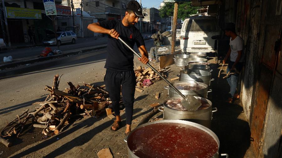 Pessoas cozinham com lenha em meio à escassez de combustível e gás em Khan Younis, no sul da Faixa de Gaza, em 15 de outubro de 2023