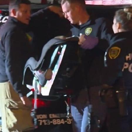 Policiais carregam bebê que foi levado após roubo de carro nos Estados Unidos - Reprodução/Khou