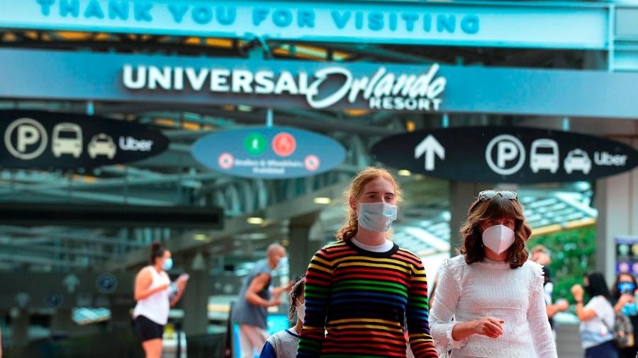 Usando máscaras, pessoas caminham em frente a parque temático do Universal Studios, na Flórida - EFE/Gerardo Mora/Archivo