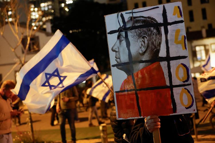 Cartazes contra Benjamin Netanyahu são vistos em protesto no centro de Tel Aviv na noite deste sábado (2)