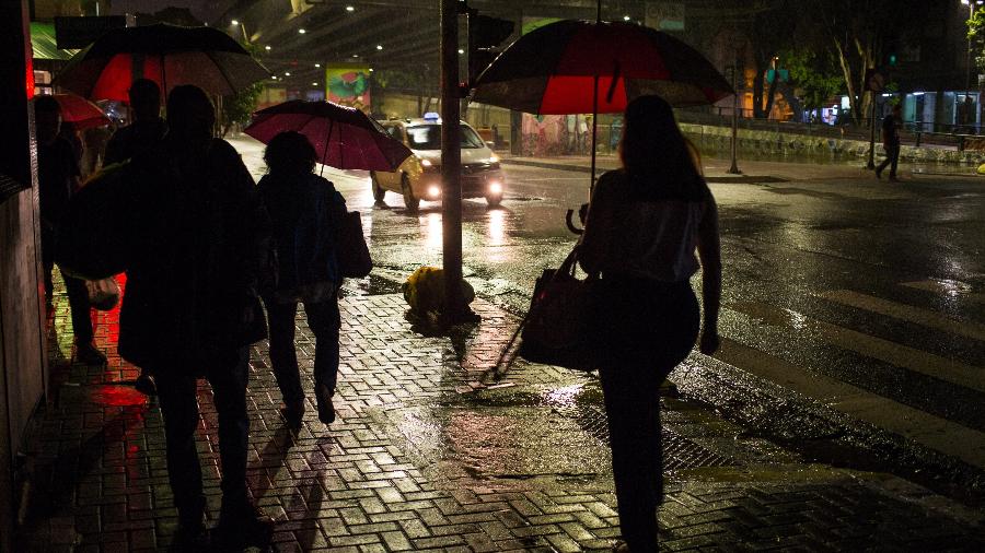 Pedestres enfrentam chuva e falta de energia nas proximidades da saída da estação Marechal Deodoro do Metrô de São Paulo, no centro da cidade, nesta segunda-feira de forte chuva na capital paulista - Tiago Queiroz/Estadão Conteúdo