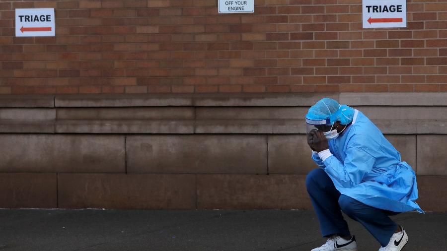 Um profissional de saúde faz uma pausa fora do centro de emergência do Maimonides Medical Center durante o surto da doença por coronavírus no bairro do Brooklyn em Nova York, EUA - ANDREW KELLY/REUTERS