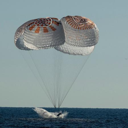 14.out.2022 - Tripulação da SpaceX é vista pousando com a cápsula Freedom com paraquedas no Oceano Atlântico, próximo ao Estado da Flórida (EUA), após deixarem a Estação Espacial Internacional. Fazem parte da missão os astronautas Kjell Lindregn, Robert Hines, Jessica Watkins e Samantha Cristoforetti  - AFP Photo/Nasa/Bill Ingalls