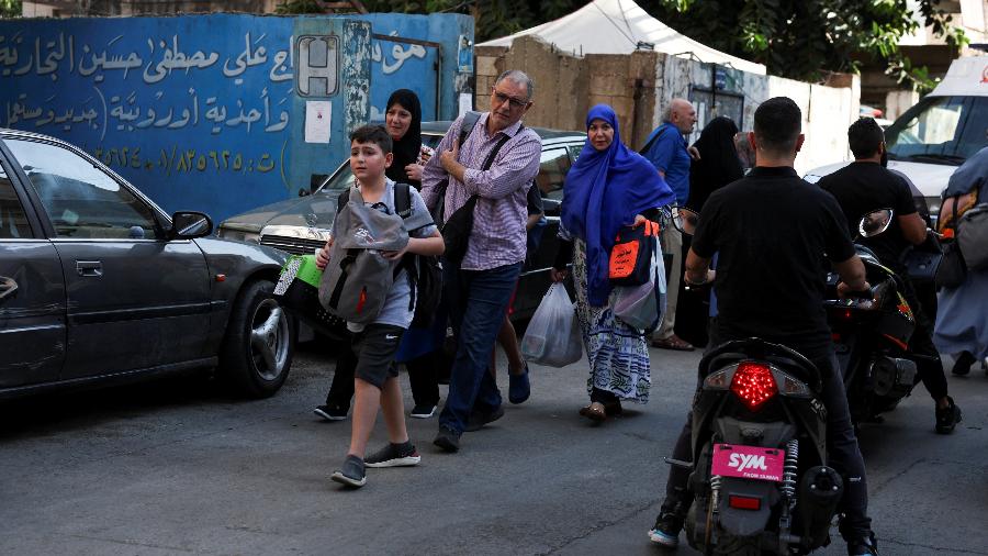 Pessoas caminham perto do local de um ataque israelense nos subúrbios ao sul de Beirute, Líbano, em 24 de setembro de 2024 - Mohamed Azakir/REUTERS