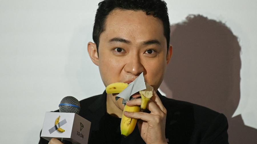 O fundador da criptomoeda nascido na China, Justin Sun, come uma obra de arte de banana composta por uma banana fresca presa a uma parede com fita adesiva, em Hong Kong, em 29 de novembro de 2024