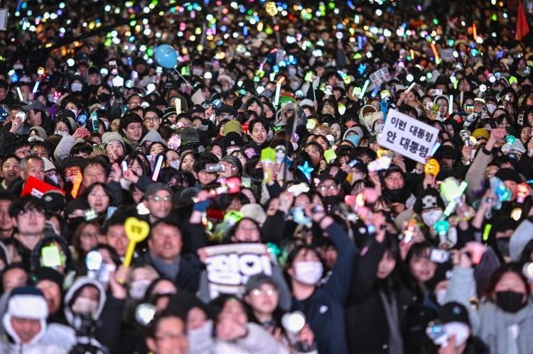 Manifestantes reagem à destituição do presidente sul-coreano Yoon Suk Yeol do lado de fora da Assembleia Nacional em Seul em 14 de dezembro de 2024