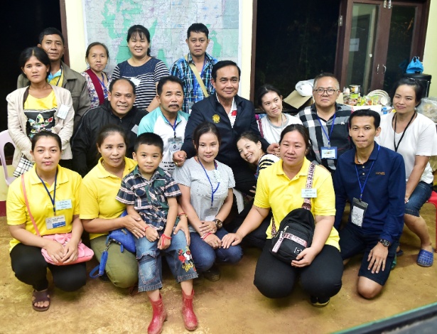 O primeiro-ministro da Tailândia, Prayuth Chan-ocha, posa com parentes de meninos presos na caverna inundada no complexo de Tham Luang em Chiang Rai - Governo da Tailândia via Reuters