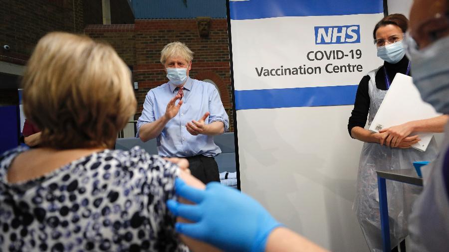 8.dez.2020 O primeiro-ministro britânico, Boris Johnson, aplaude após paciente receber dose da vacina contra covid-19 - Frank Augstein/POOL/AFP
