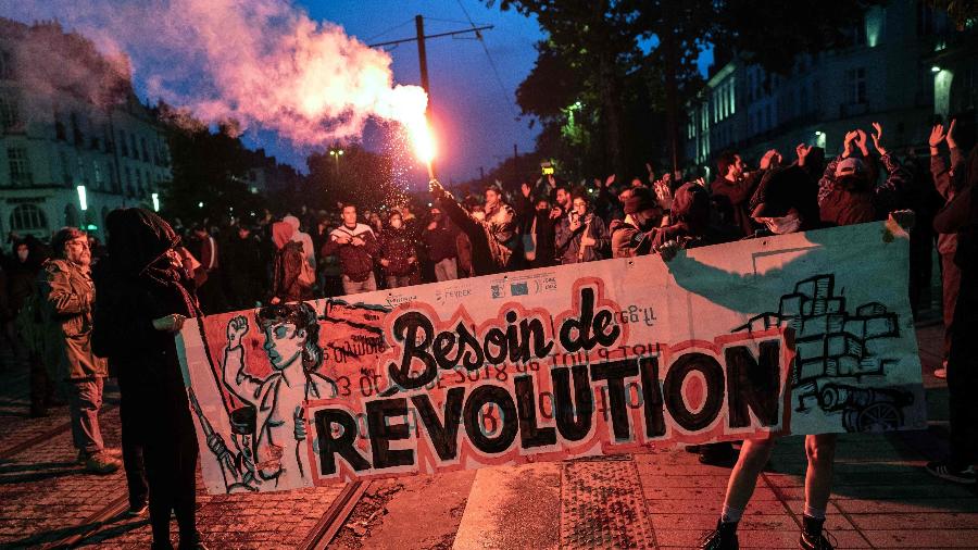 24.abri.22 - Manifestantes seguram faixa com a frase "uma necessidade de revolução" em Nantes, após os resultados das eleições presidenciais na França - Loic VENANCE / AFP