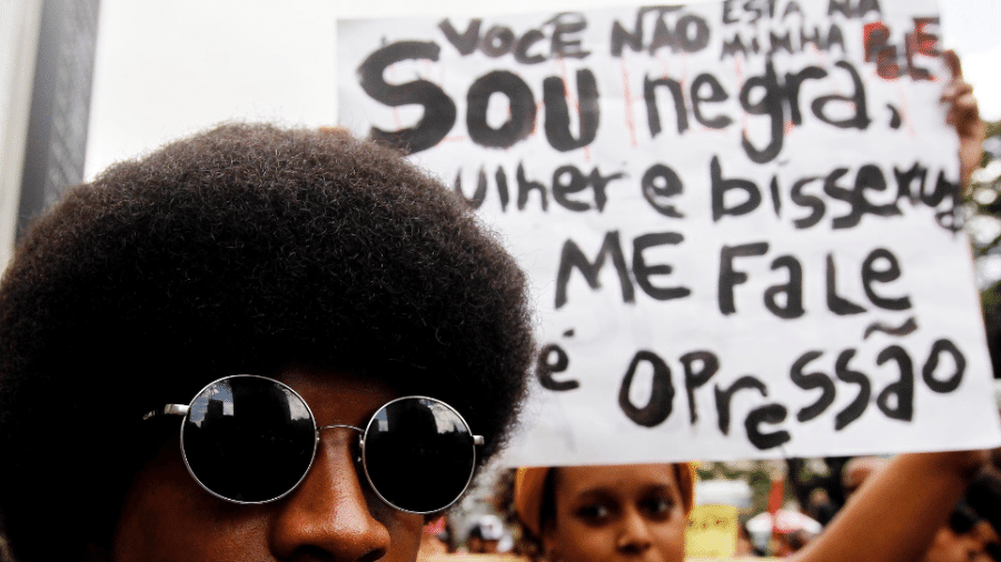 Manifestantes carregam cartazes durante a Marcha da Consciência Negra em 2013.