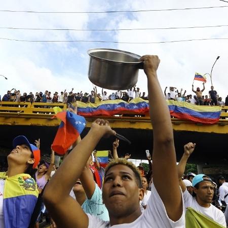 Um homem bate em uma panela durante um protesto contra o governo do presidente venezuelano Nicolás Maduro, na Venezuela