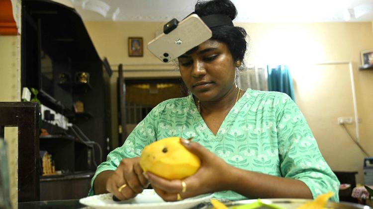 Mulher indiana se grava cortando fruta para treinar robôs Mulher indiana se grava cortando fruta para treinar robôs