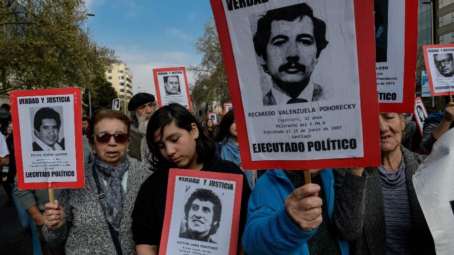 8.set.2019 - Manifestantes mostram fotos de desaparecidos durante a ditadura no Chile em protesto contra o regime de Pinochet - Martin Bernetti/AFP