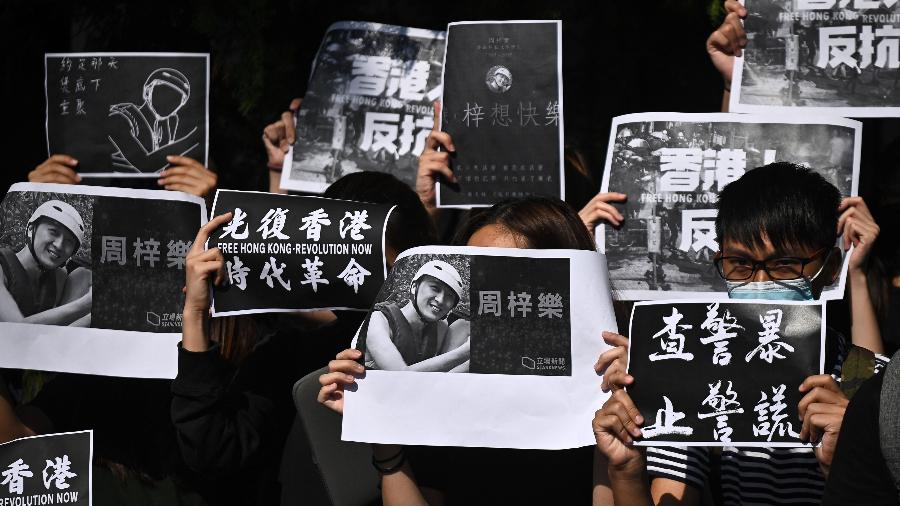 Estudantes da Universidade de Ciência e Tecnologia de Hong Kong participam de uma marcha após a morte do estudante Alex Chow, 22, após confrontos entre policiais e manifestantes. - Philip FONG / AFP