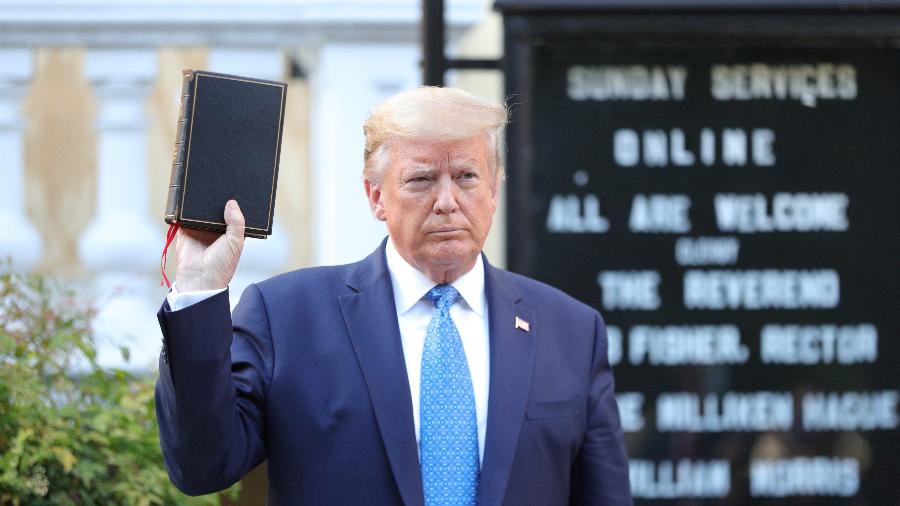 O presidente dos EUA, Donald Trump, segura uma Bíblia enquanto fica em frente à Igreja Episcopal de São João em frente à Casa Branca - TOM BRENNER/REUTERS