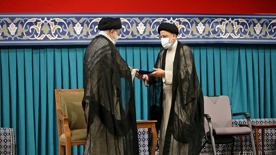 3.ago.2021 - O líder supremo do Irã, aiatolá Ali Khamenei, durante a cerimônia de posse de Ebrahim Rais (direita) - AFP/HO/Khamenei.IR
