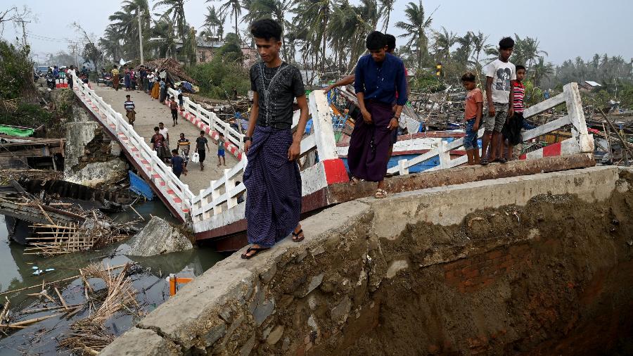 15.mai.23 - Pessoas atravessam uma ponte quebrada no campo de refugiados Khaung Dote Khar Rohingya em Sittwe - SAI AUNG MAIN/AFP