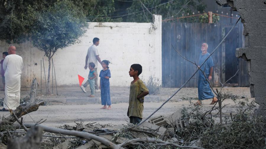 12.ago.2024 - Moradores analisam os estragos causados por um bombardeio de Israel em Nuseirat, na região central da Faixa de Gaza