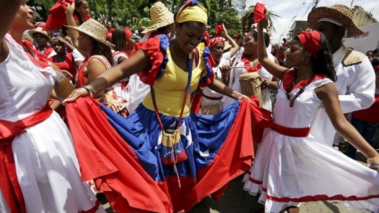 Mulher dança na frente da estátua de San Juan na aldeia de Curiepe. A festa tem raízes europeias e africanas