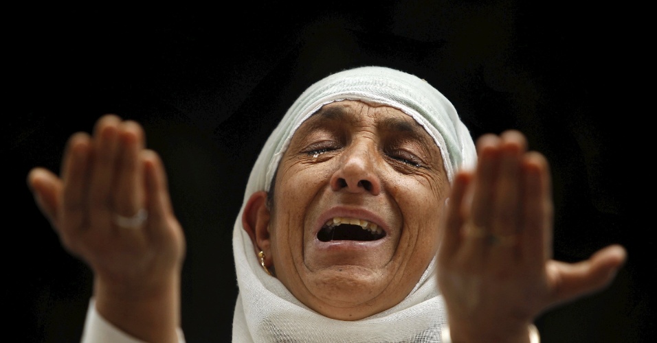 21.set.2015 - Mulher muçulmana chora enquanto reza no santuário de Mir Syed Ali Hamdani, durante um festival religioso, em Srinagar, na Índia