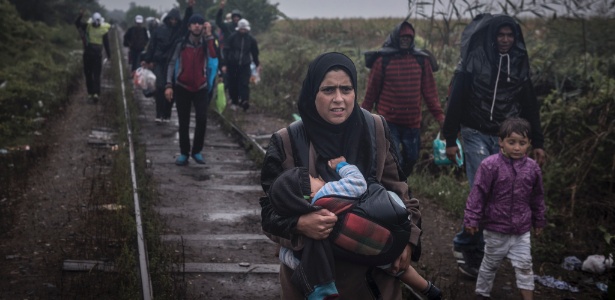 Refugiados caminham nos trilhos de trem próximo à fronteira entre Sérvia e Hungria - Sergey Ponomarev/The New York Times