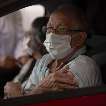 24.mar.2020 - De máscara, idoso recebe vacinação contra a gripe no bairro da Tijuca, no Rio de Janeiro (RJ) - Mauro Pimentel/AFP