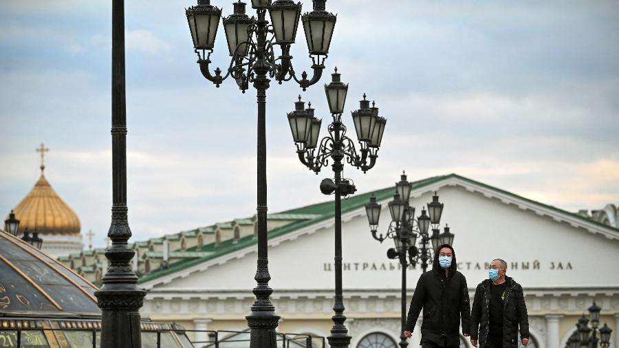 22.out.2021 - Pedestres usando máscaras caminham no centro de Moscou, em meio à crise ligada à pandemia de covid-19 - Alexander Nemenov/AFP
