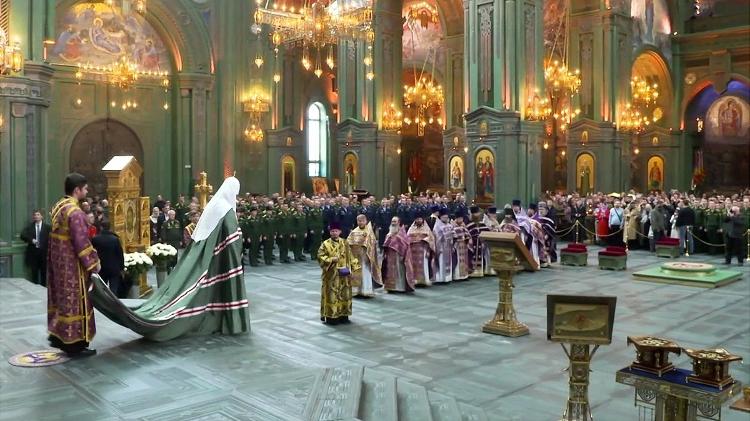 Father Cirilo in green robes at a recent ceremony attended by military personnel - DESCRIPTION - DESCRIPTION