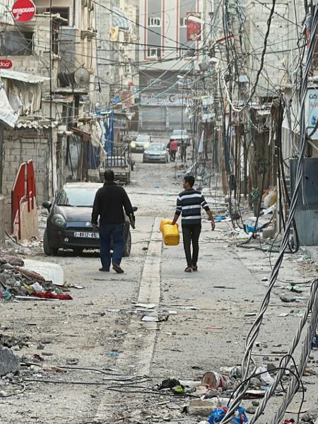 26.nov.2023 - Pessoas caminham entre casas destruídas pelos ataques israelenses, em meio a uma trégua temporária entre Israel e Hamas, na cidade de Gaza 