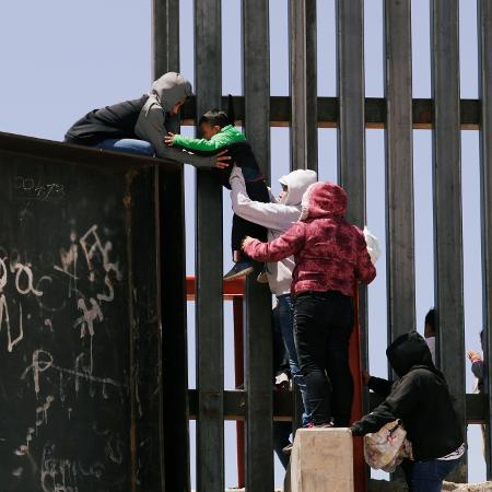 22.jun.2019 - Migrantes pulam sobre muro para cruzar a fronteira dos EUA com o México em Ciudad Juarez - Jose Luis Gonzalez/Reuters
