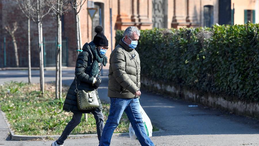 22.fev.2020 - Homem e mulher usando máscaras andam na rua em Codogno, na Itália - Flavio Lo Scalzo/Reuters