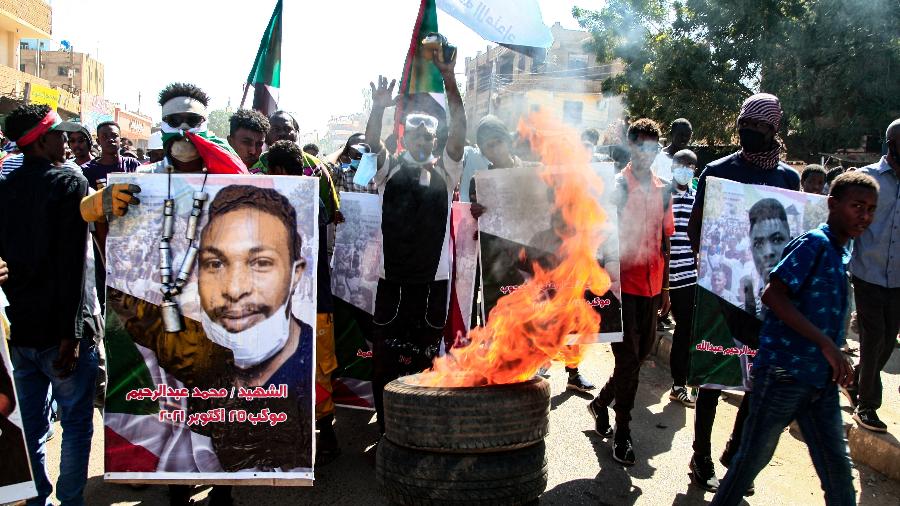 30.dez.21 - Sudaneses carregam cartazes de manifestantes mortos durante protesto na capital Cartum contra o golpe do exército de 25 de outubro - -/AFP