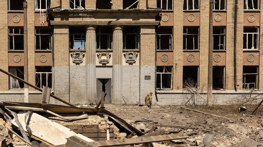 08.mai.22 - Soldado ucraniano caminha em frente a escola que foi bombardeada em meio à invasão russa na Ucrânia, em Kostyantynivka, na região de Donetsk, Ucrânia - JORGE SILVA/REUTERS