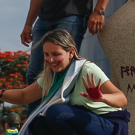 08.01.2023 - Débora Rodrigues picha a estátua da Justiça, na praça dos Três Poderes - Gabriela Biló/Folhapress