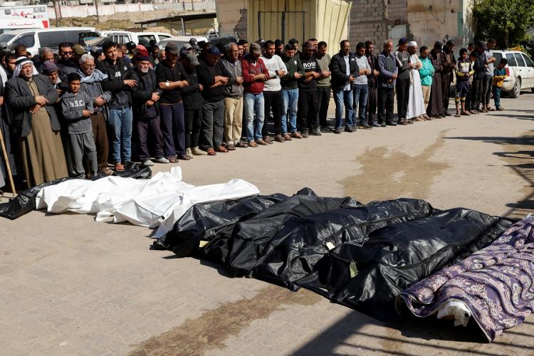 Pessoas em luto rezam durante o funeral dos palestinos mortos em ataques israelenses, no hospital Nasser, em Khan Younis, no sul da Faixa de Gaza, em 17 de abril de 2025.