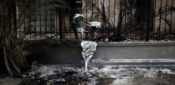 Flores são colocadas em grade de local onde duas pessoas morreram em incêndio na Grécia - Alkis Konstantinidis/Reuters